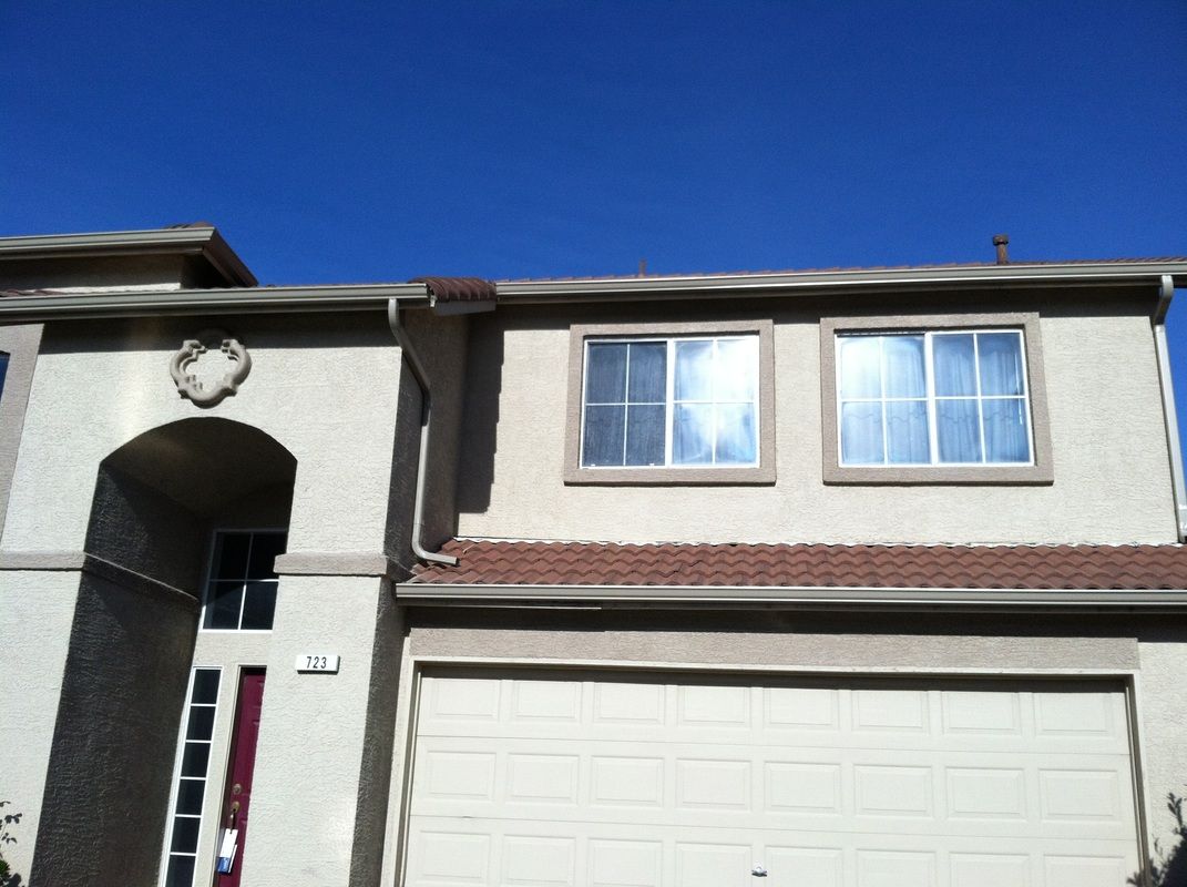 A house with a garage and a blue sky in the background