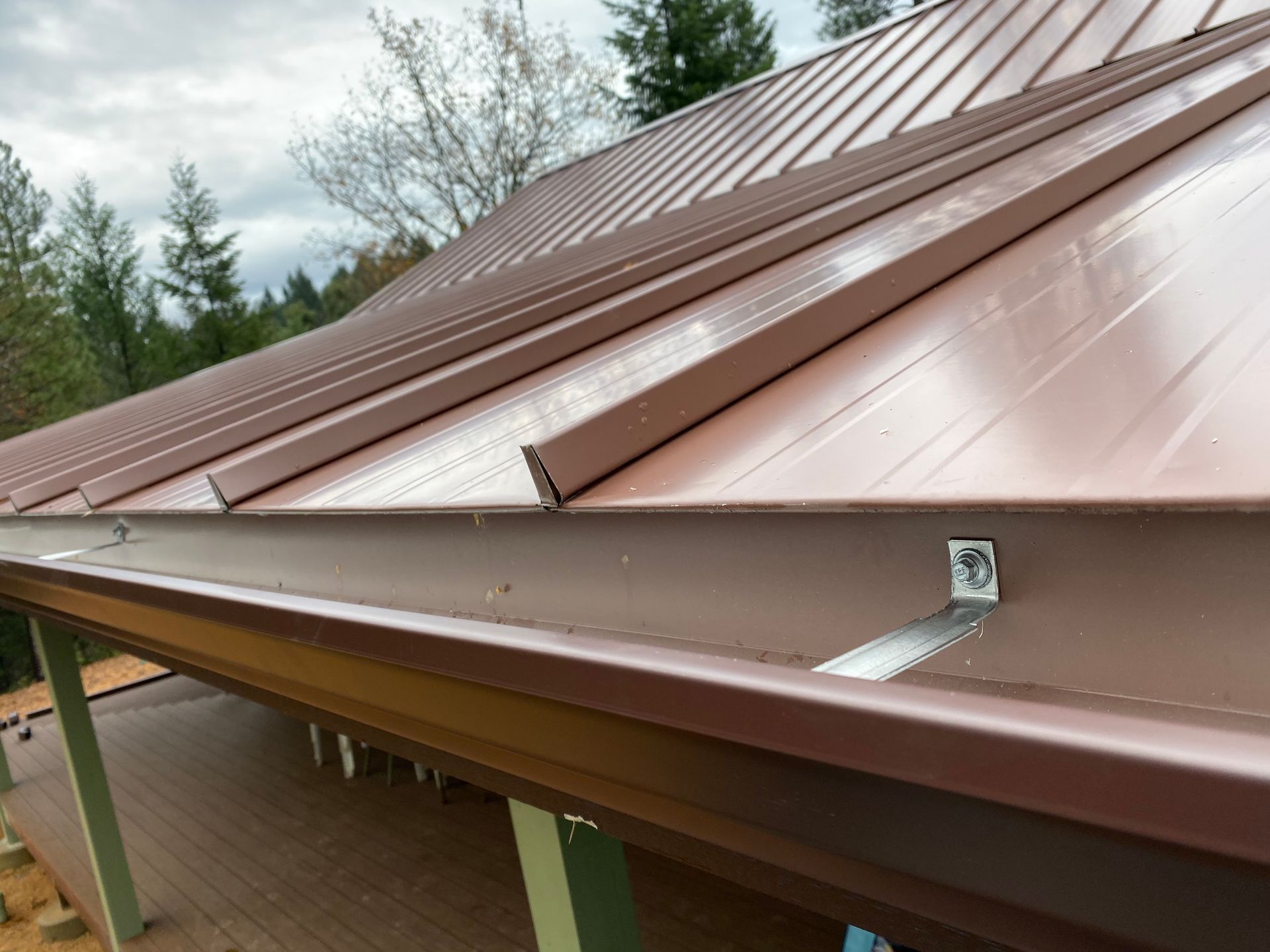 The roof of a house with a wooden roof and a black gutter.