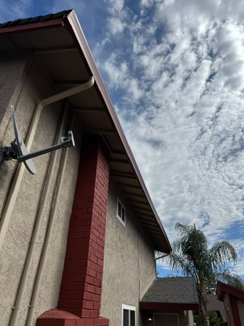 A house with a red chimney and a satellite dish on the side