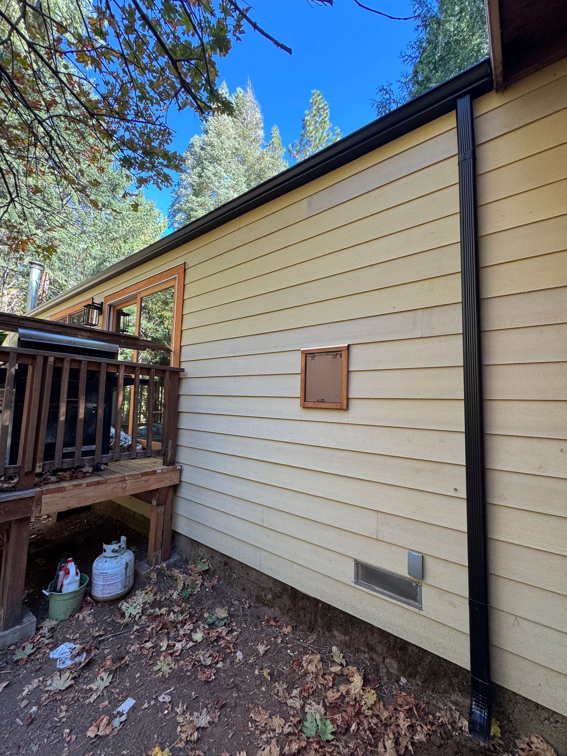 A house with a deck and a gutter on the side of it.