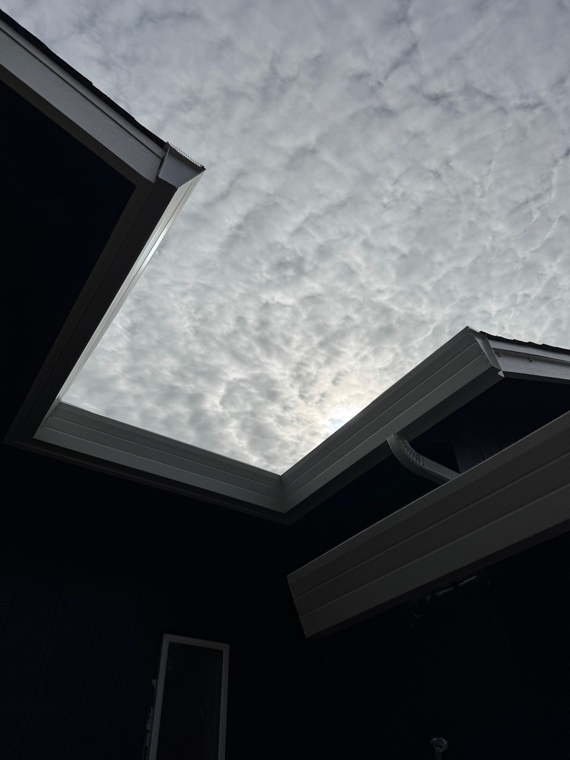 Looking up at the sky from the roof of a house seeing the clean gutters
