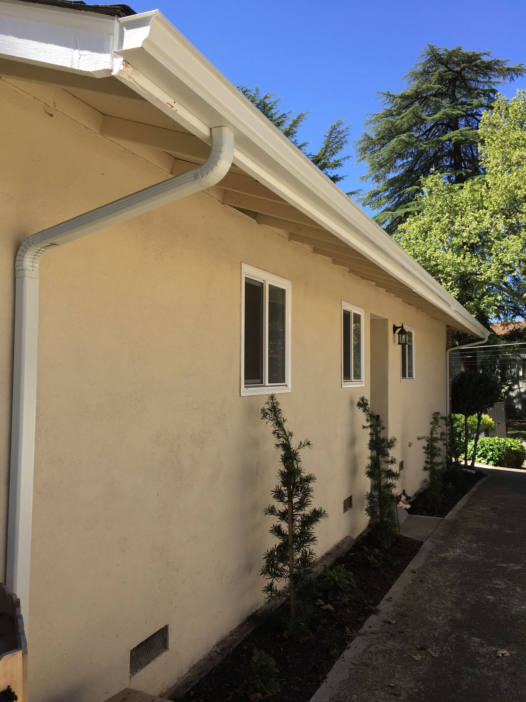 A house with a white gutter on the side of it