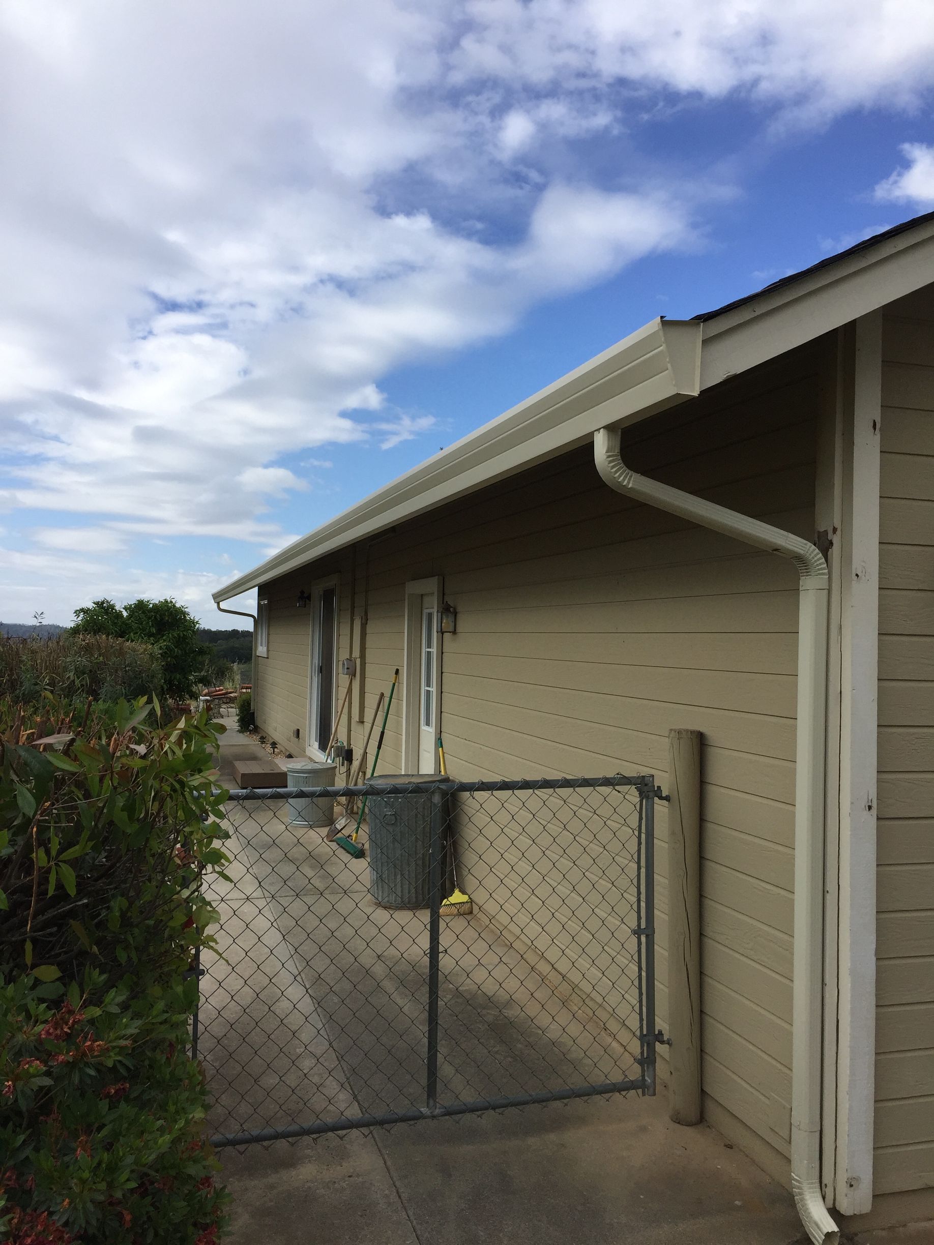 A white house with a chain link fence in front of it