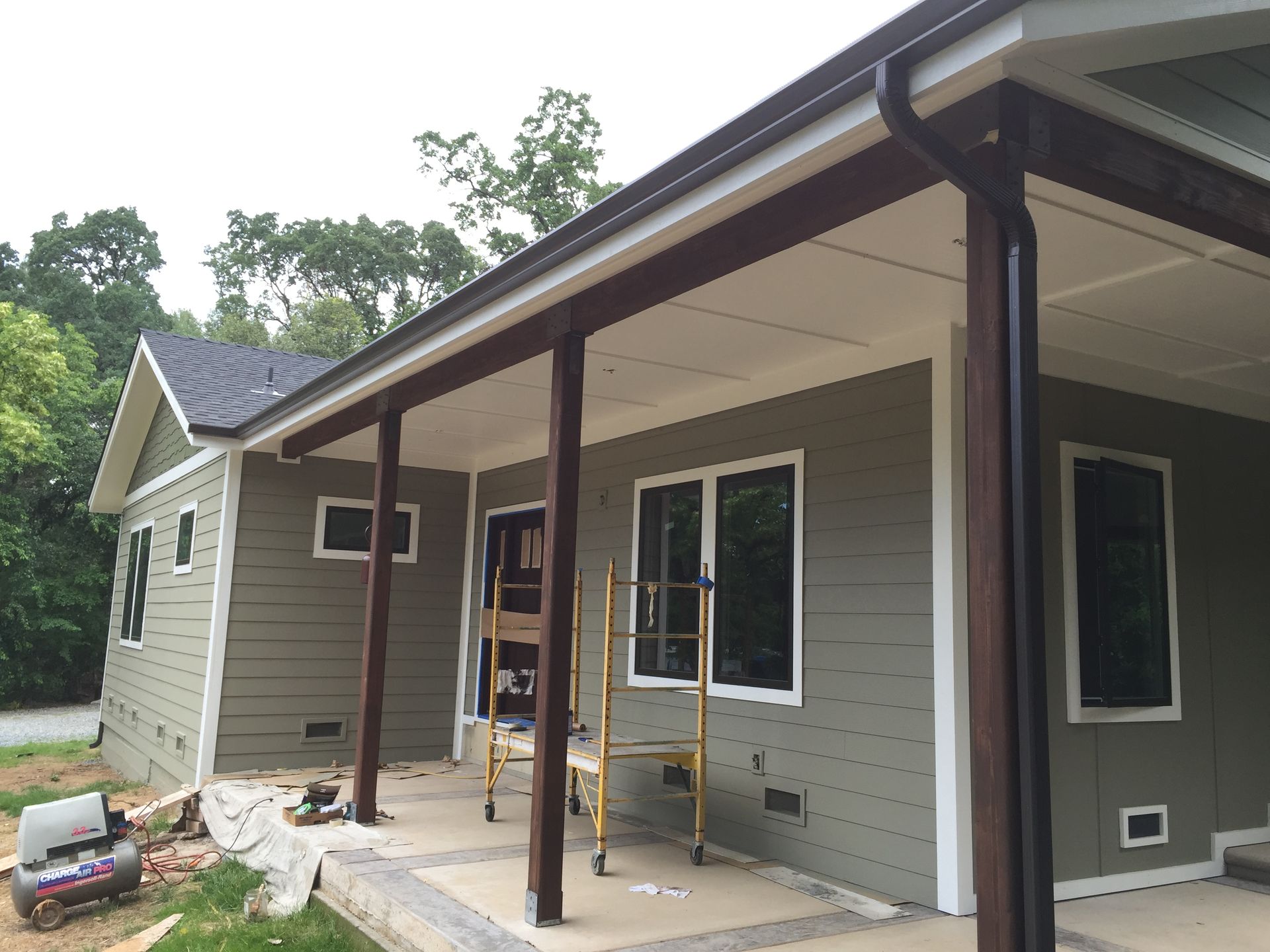 A house with a porch and rain gutter in front of it