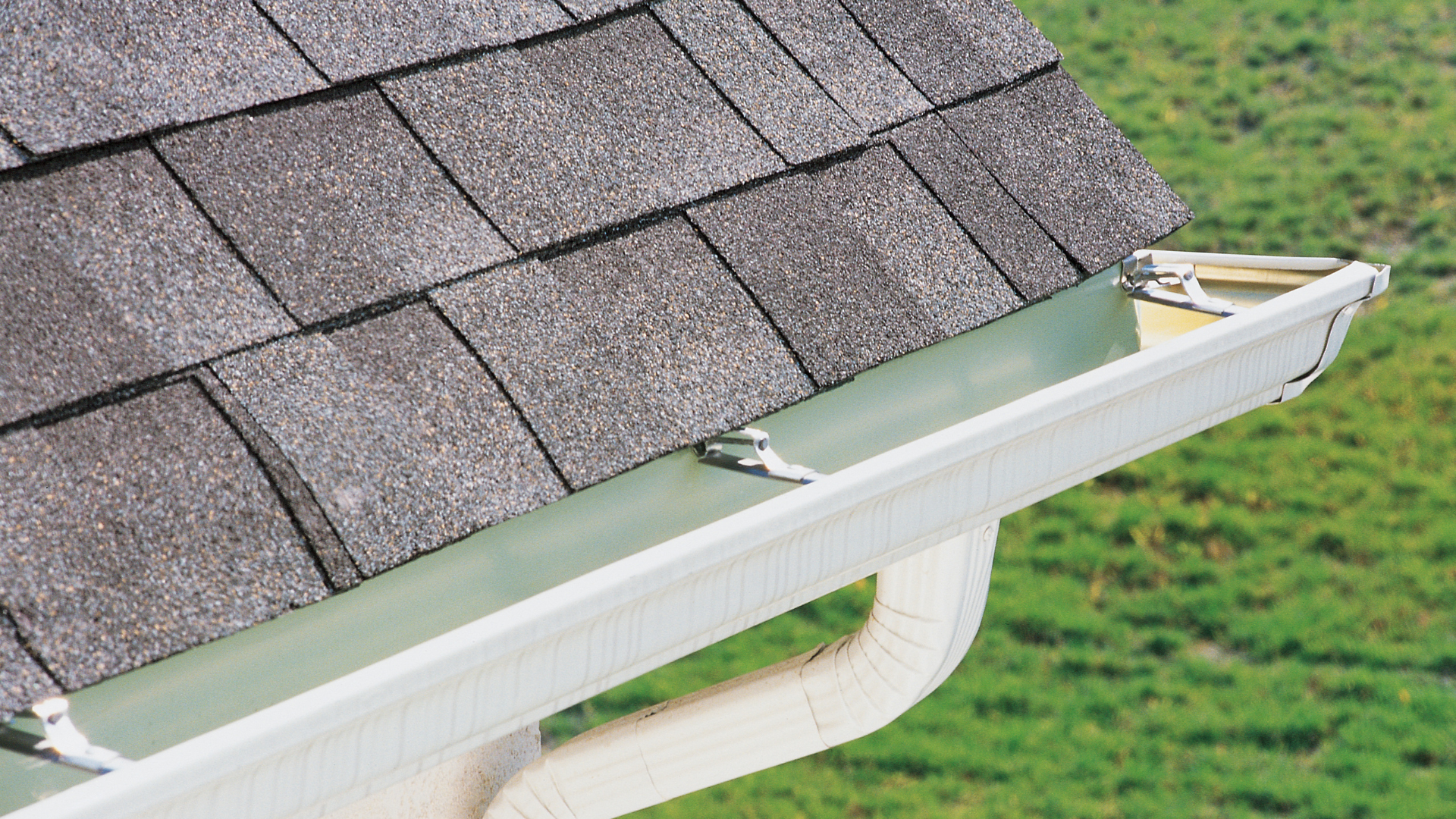 The roof of a house with a wooden roof and a black gutter.