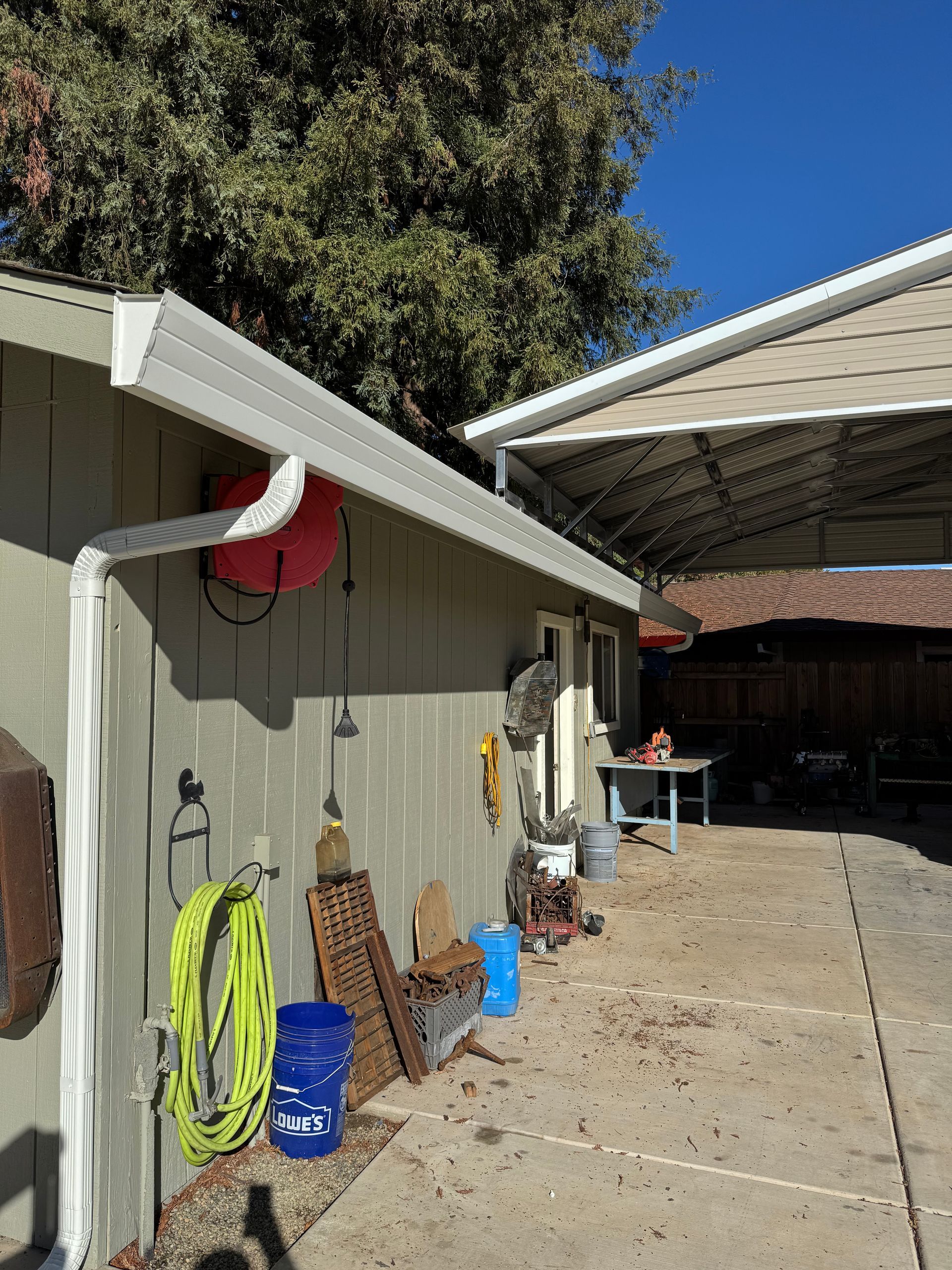 A house with a carport and a gutter on the side of it.