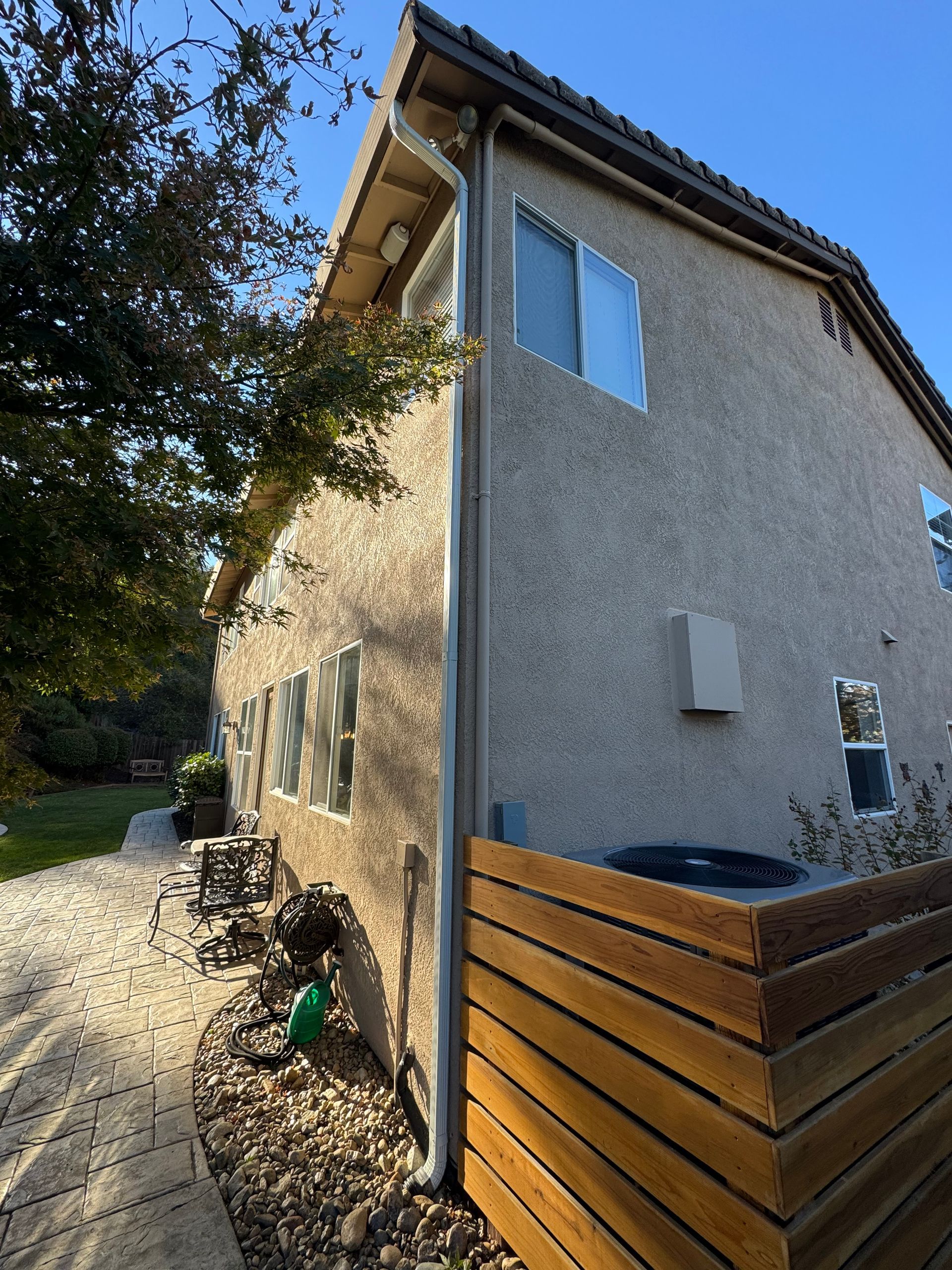 A house with a wooden fence in front of it. Gutter has been cleaned out