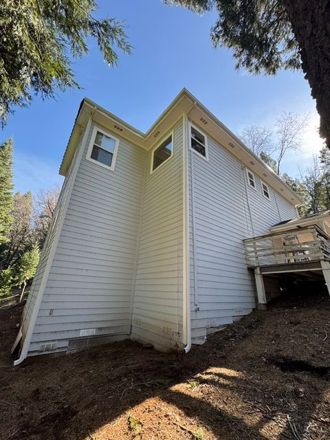 A white house with yellow siding and a deck