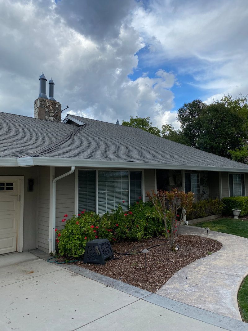 A house with a gray roof and a white garage door.