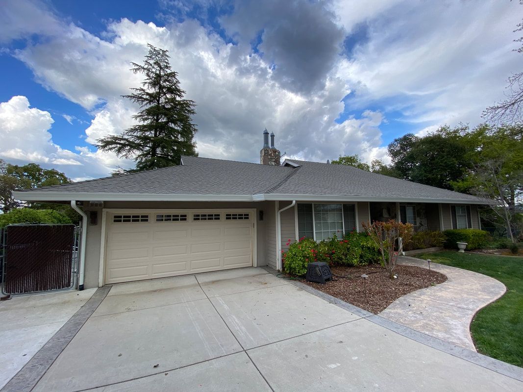 A house with a garage and a walkway in front of it.