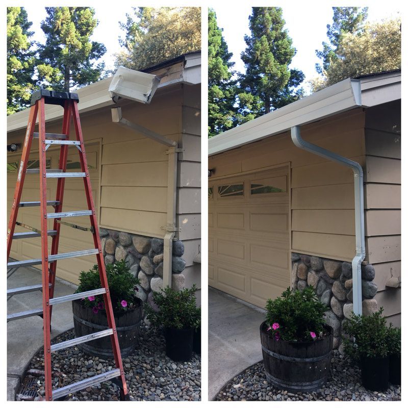 A ladder is sitting on the side of a house next to a garage door.