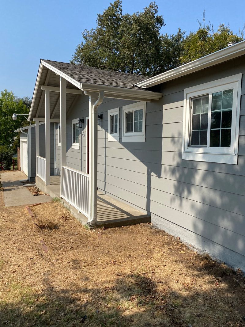 A house with a porch and a lot of windows.