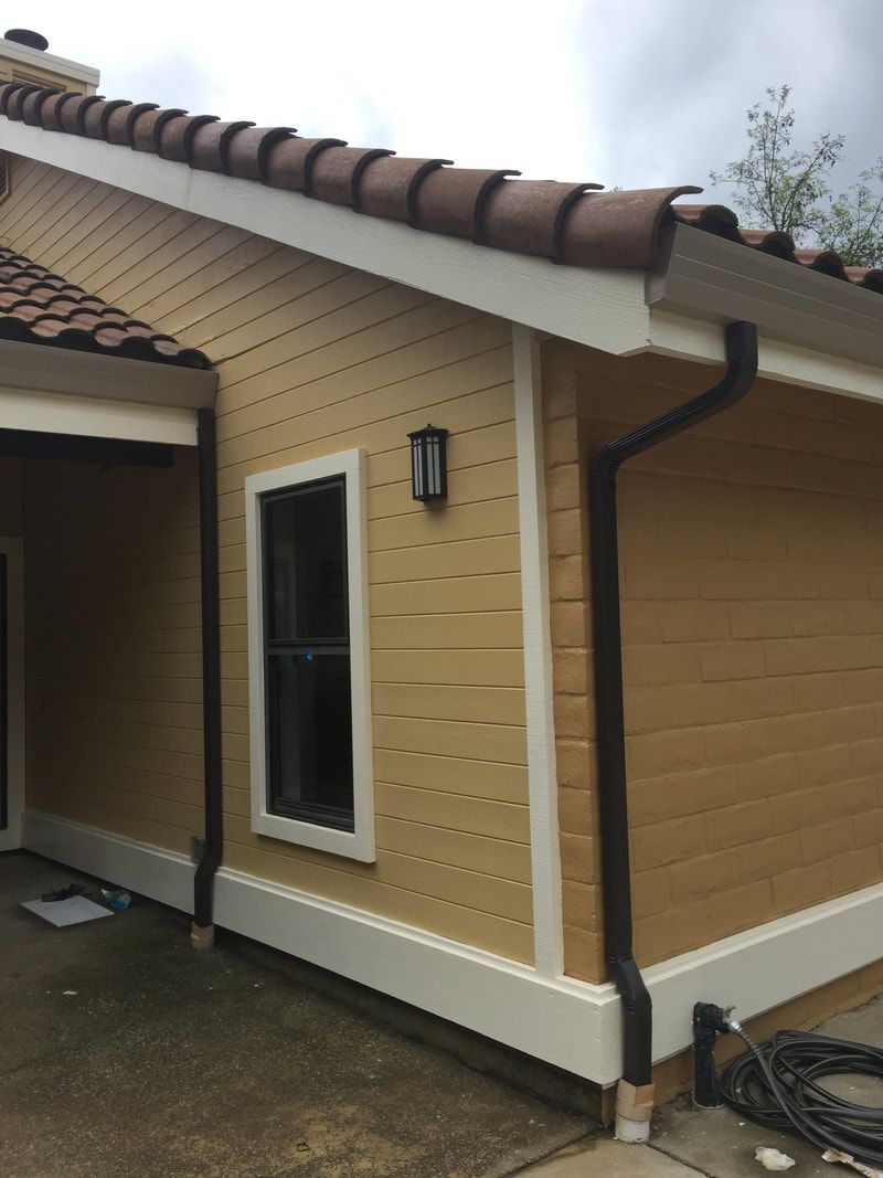 A house with a tiled roof and a gutter on the side of it.