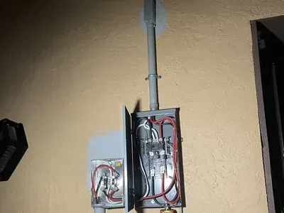 A electrical box is hanging on a wall next to a door.