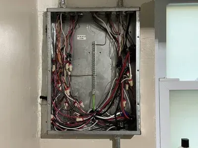 A very messy electrical box with a lot of wires coming out of it.