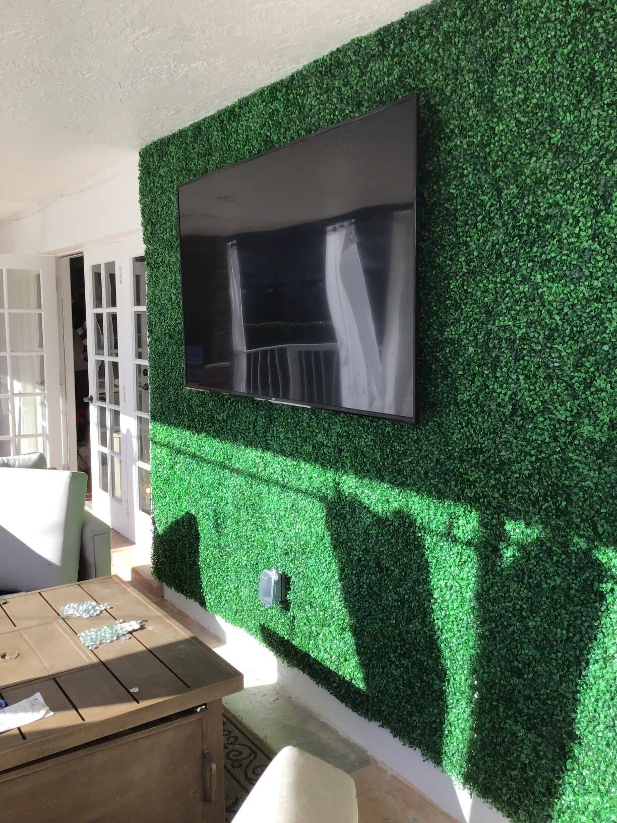 A living room with a green wall and a flat screen tv.