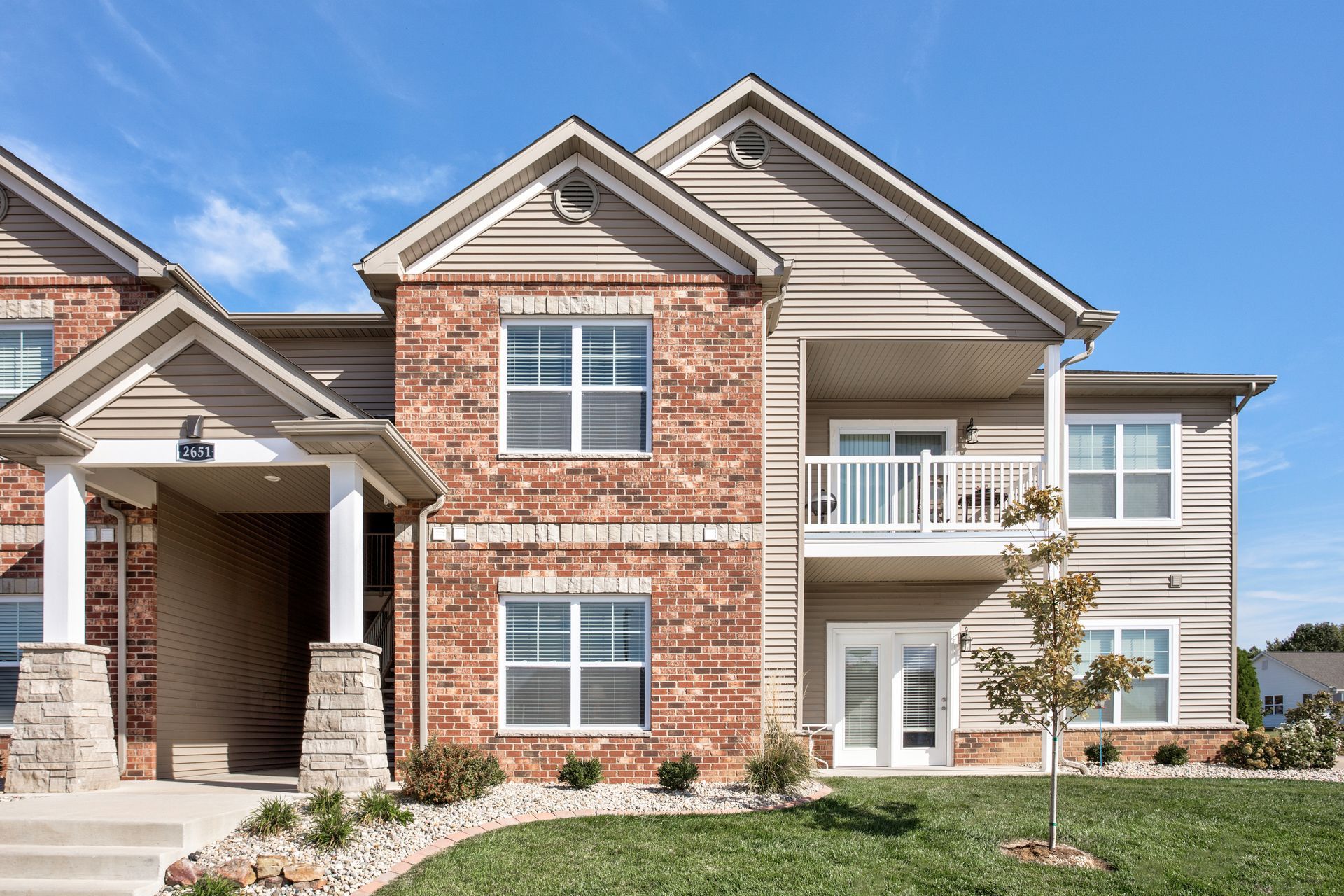 A large brick house with a lot of windows and a balcony.