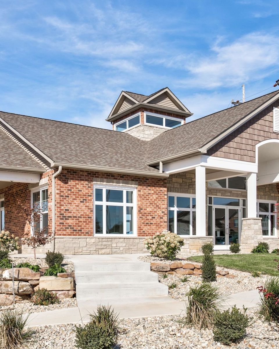 A large brick house with a large roof and a lot of windows.
