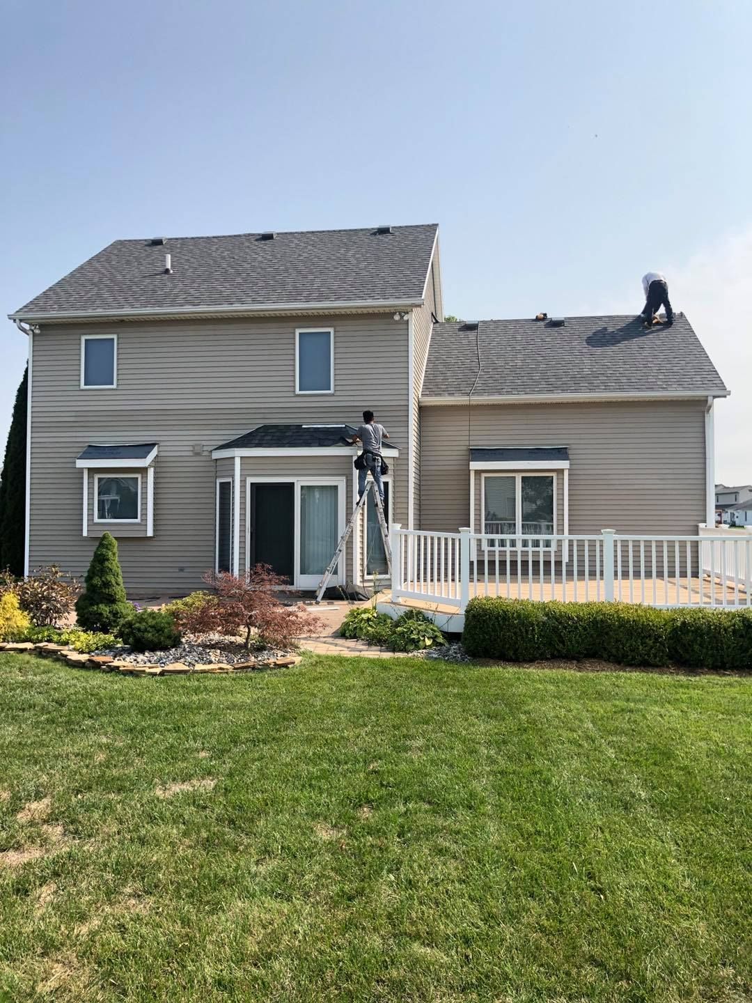 A man is painting the side of a house.
