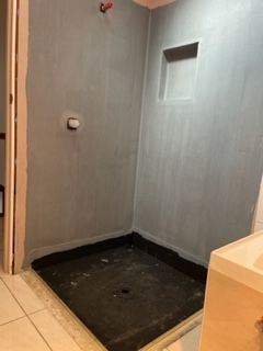A bathroom with a shower stall and a toilet.