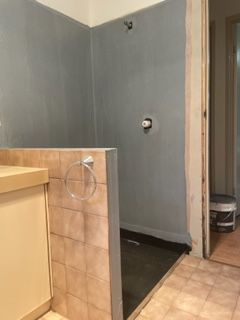 A bathroom with a walk in shower and a sink.