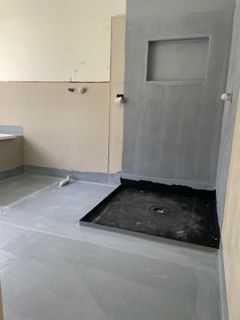 A bathroom with a walk in shower and a sink.