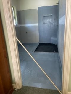 A bathroom with a blue tiled floor and a walk in shower.