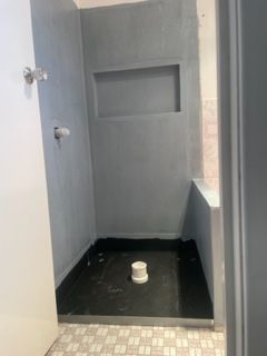 A bathroom with a shower stall and a toilet.