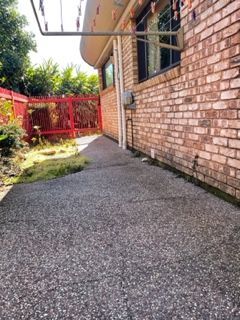 A brick building with a concrete walkway leading to it.