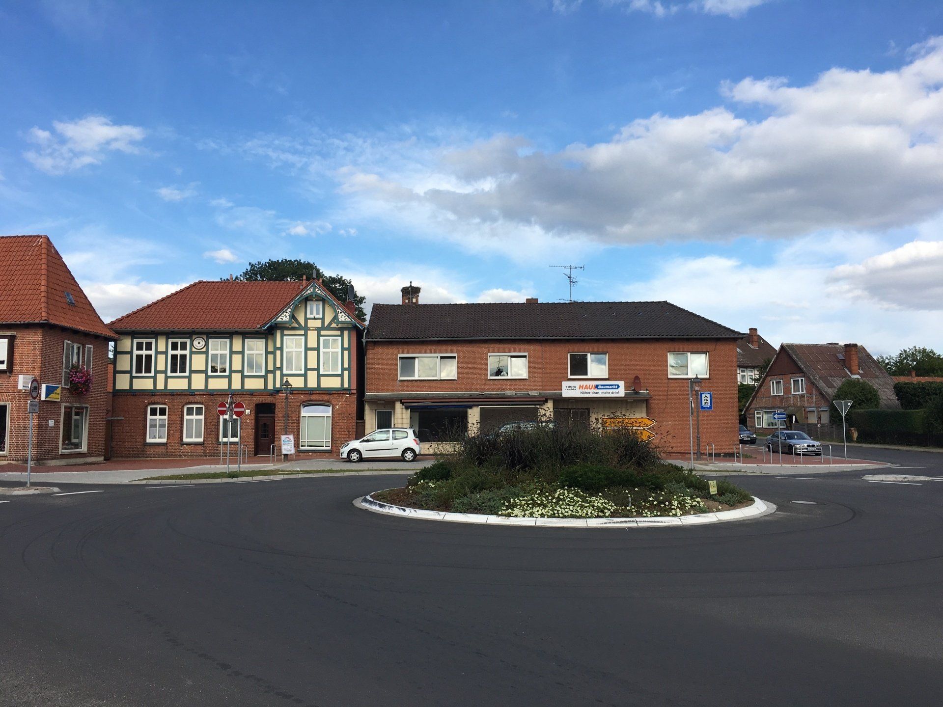 In der Mitte der Straße befindet sich zwischen zwei Gebäuden ein Kreisverkehr.