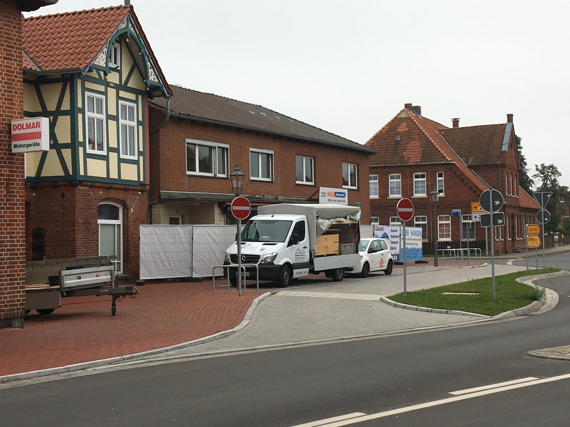 Ein weißer Lieferwagen steht vor einem Backsteingebäude