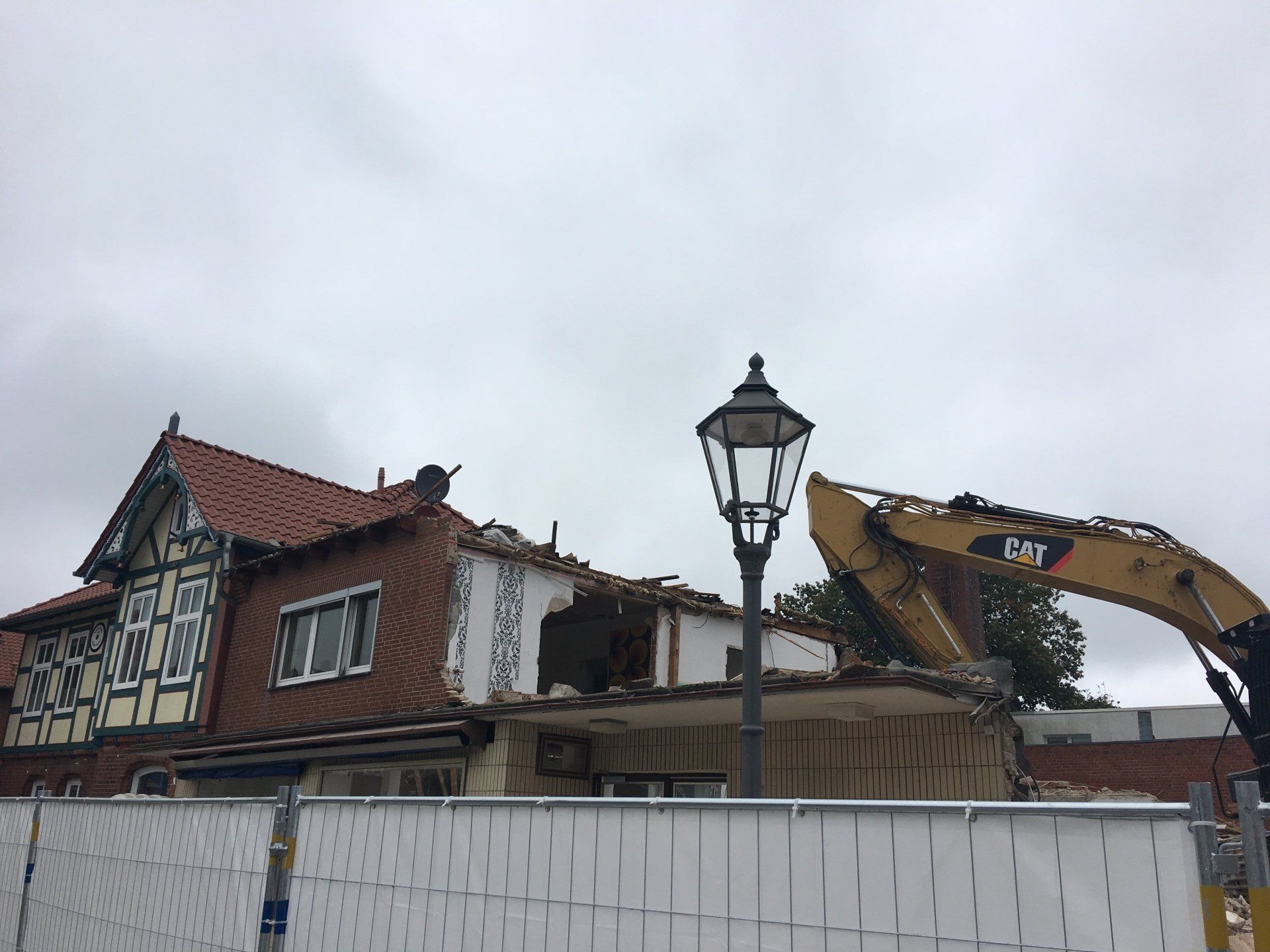 Ein Haus wird von einem Cat-Bagger abgerissen.