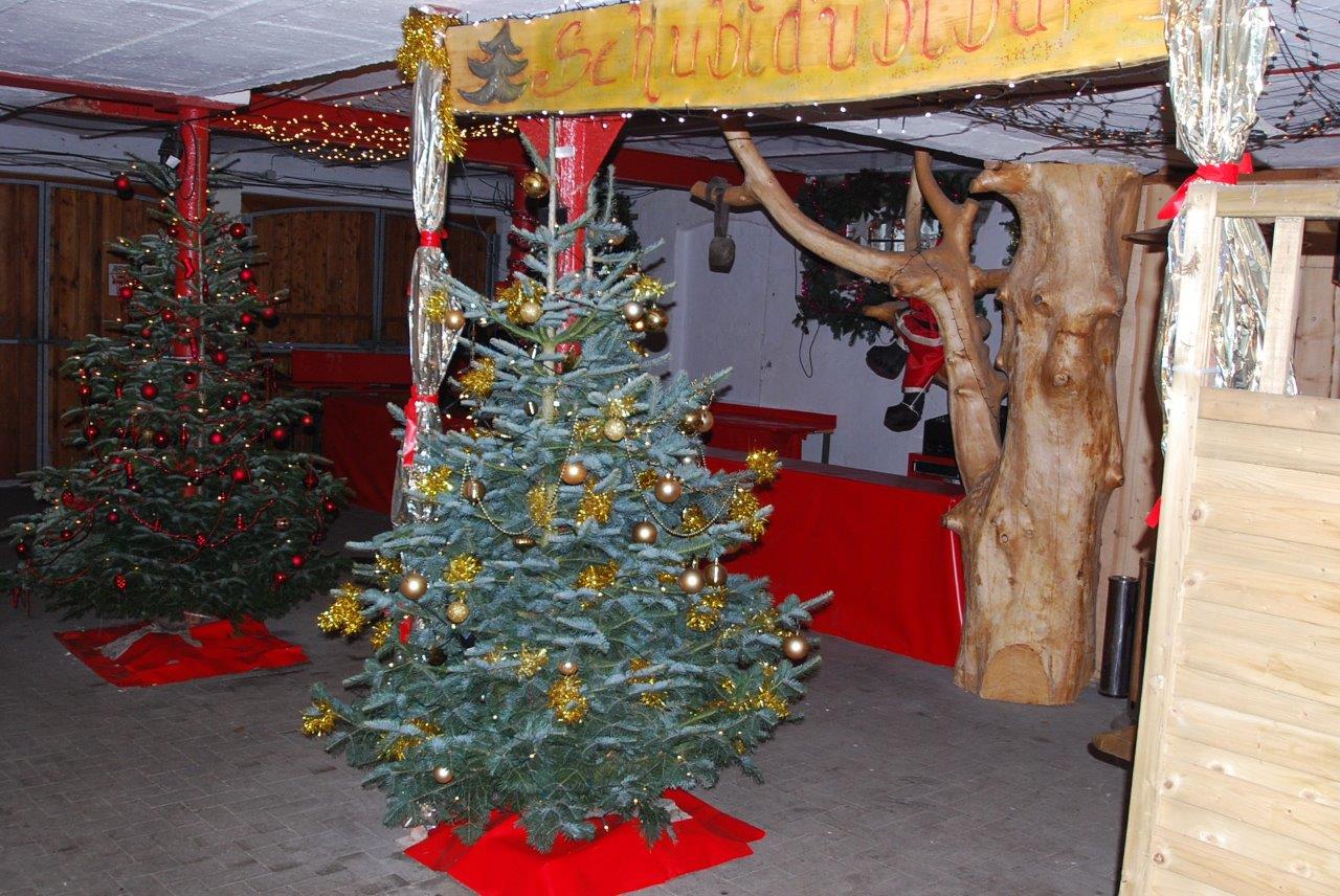 Ein Weihnachtsbaum in einem Raum mit einem Schild mit der Aufschrift „Weihnachten“