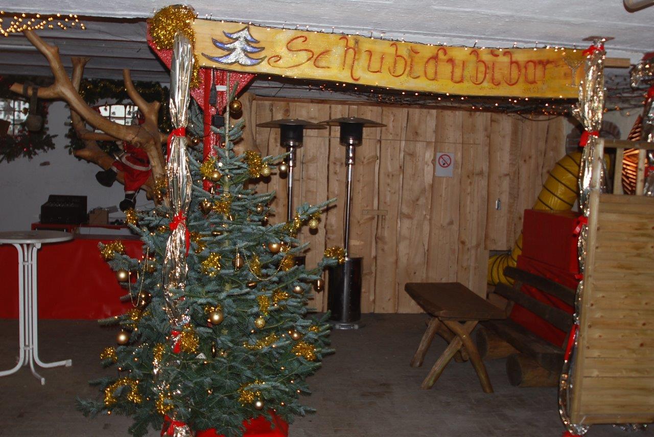 Ein Weihnachtsbaum steht vor einem Schild mit der Aufschrift Schubert Bier