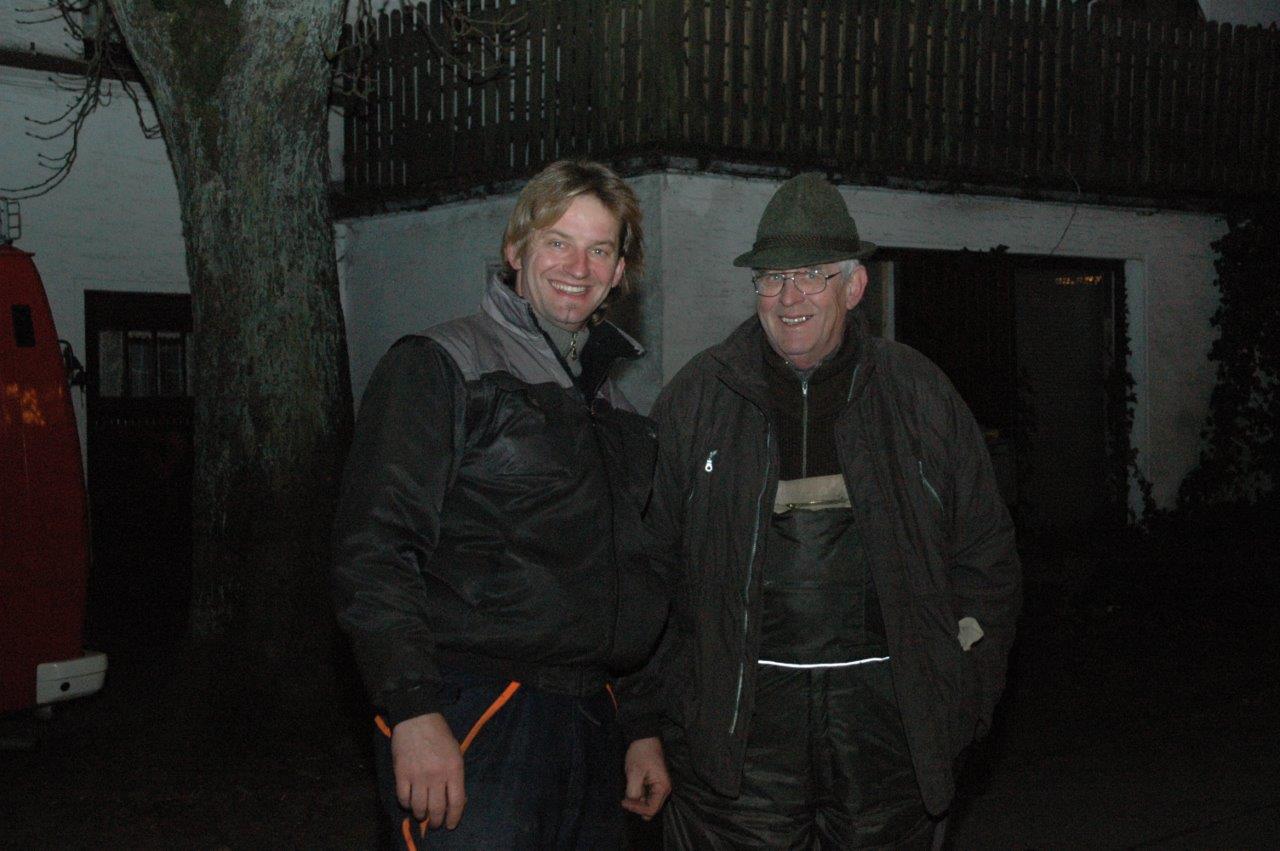 Zwei Männer stehen nebeneinander vor einem Gebäude.