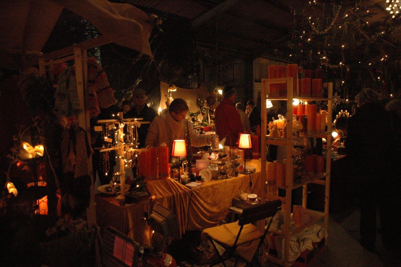 Eine Gruppe von Menschen steht in einem dunklen Raum um einen Tisch herum.