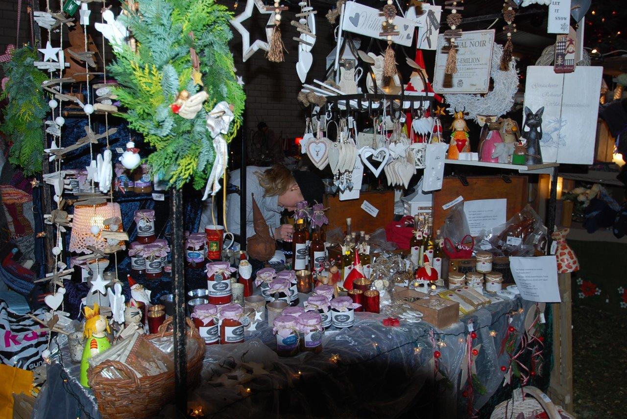 Eine Frau sitzt an einem Tisch mit viel Weihnachtsdekoration darauf