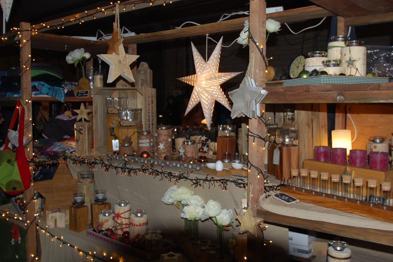 Ein Holzregal mit Kerzen und Sternen darauf