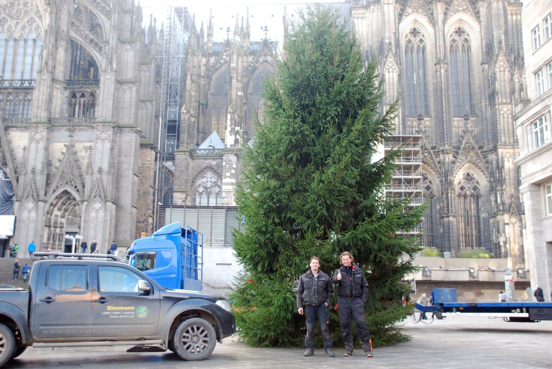 Zwei Männer stehen vor einem gro0en Weihnachtsbaum vor dem Kölner Dom