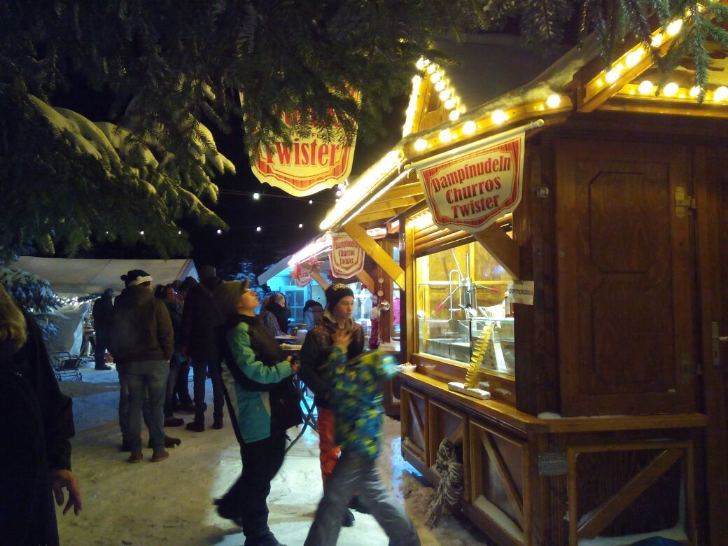 Eine Gruppe von Menschen steht vor einem Stand mit der Aufschrift „Fenster“