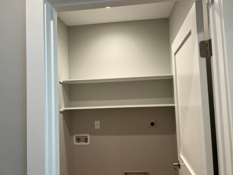 A laundry room with shelves and a door.