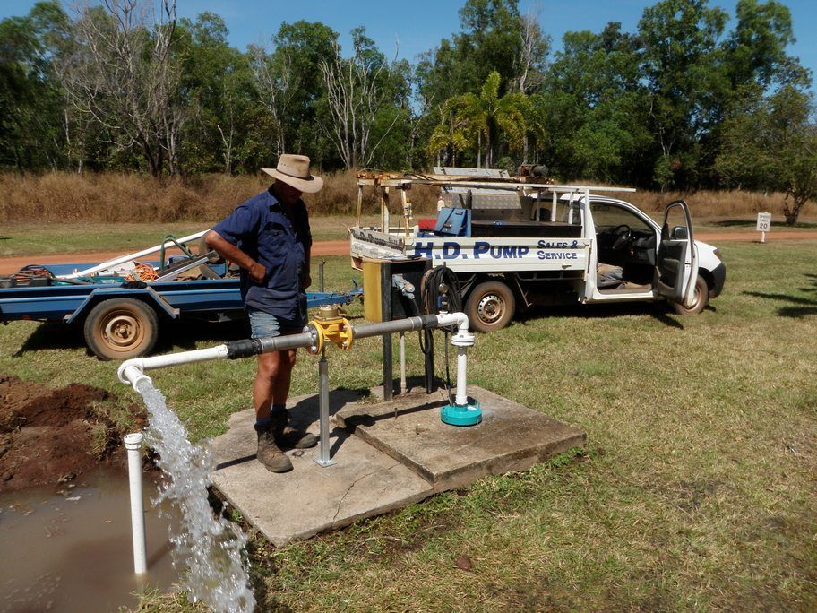 A man is standing in front of a truck that says h.d. pump service