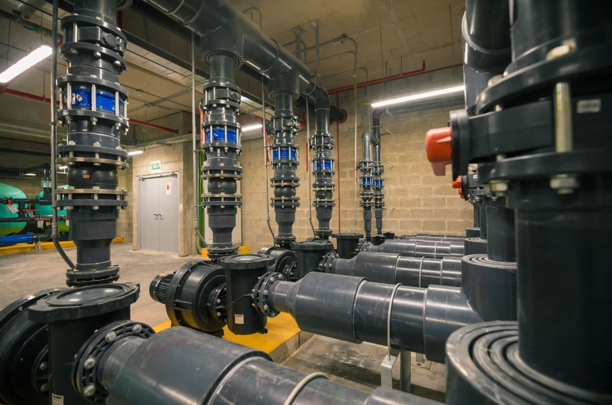 A room filled with lots of pipes and valves in a factory.