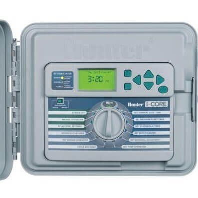 A sprinkler controller with the lid open and a green screen.