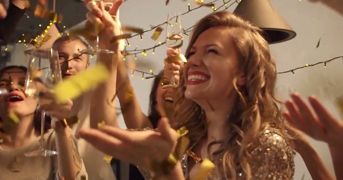 A smiling woman celebrating with colleagues at a corporate party