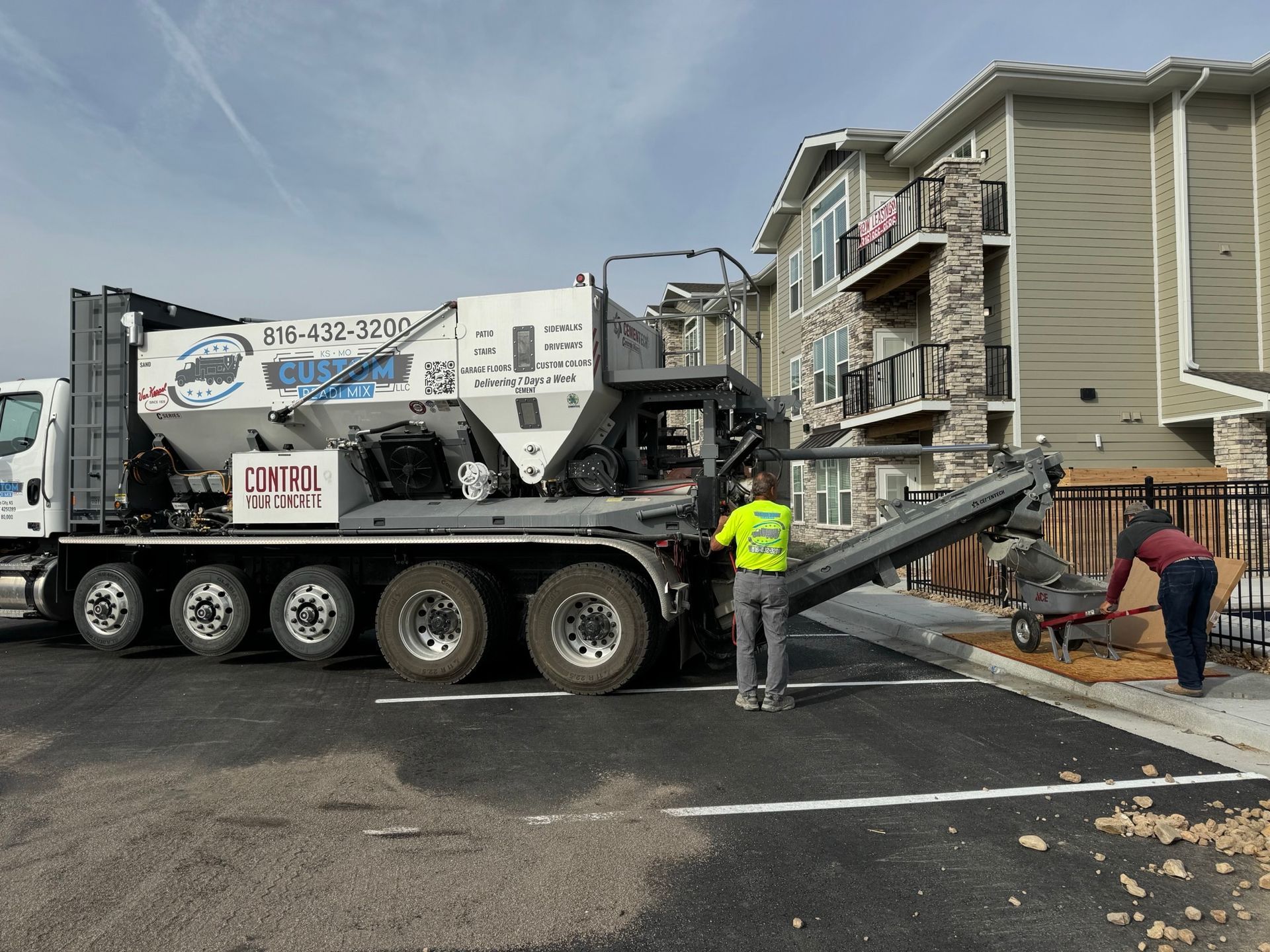 White truck refueling at a Fleet Fuels station, a yellow Hyundai loader in background.