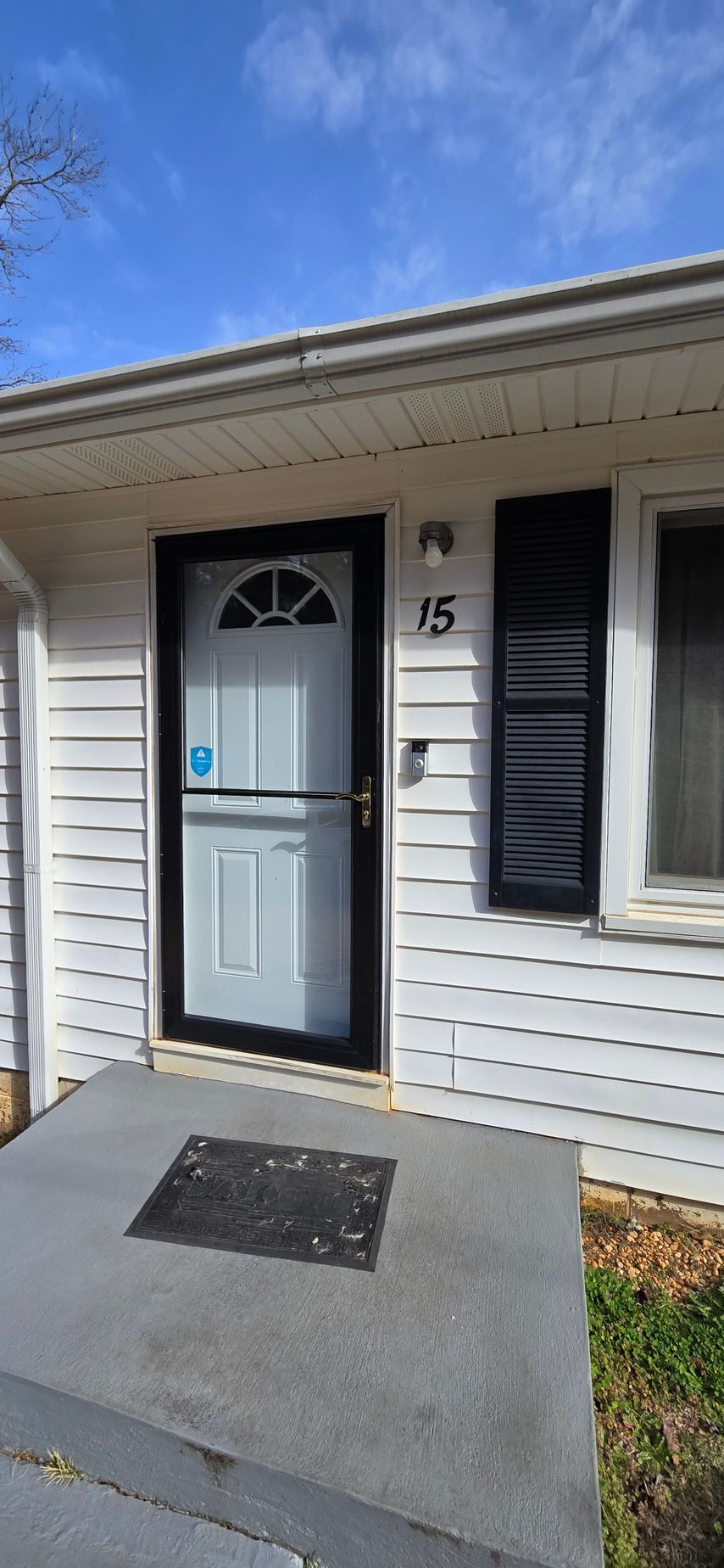 Exterior of a white building with a front door. 