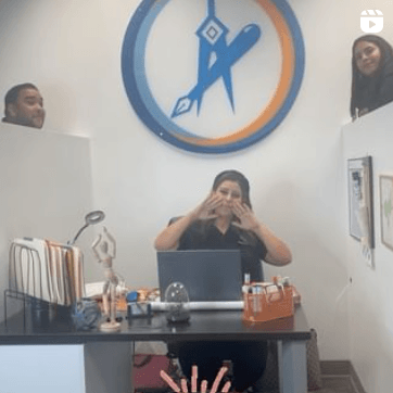 Una mujer está sentada en un escritorio con una computadora portátil frente a ella