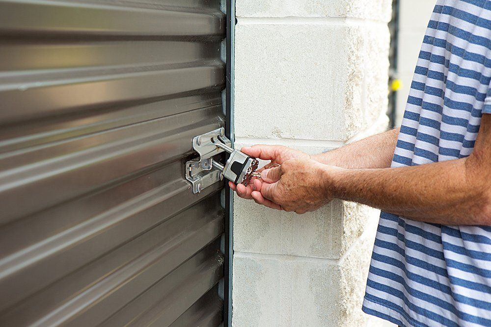 Person Locking Up The Storage Unit Door — Fairfield, CA — Cement Hill Storage Person Locking Up The Storage Unit Door — Fairfield, CA — Cement Hill Storage