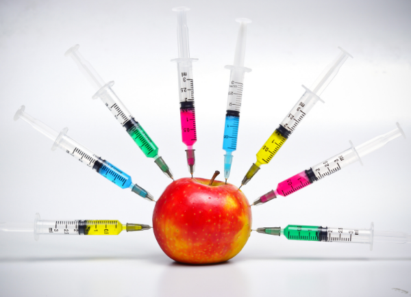syringes sticking in an apple